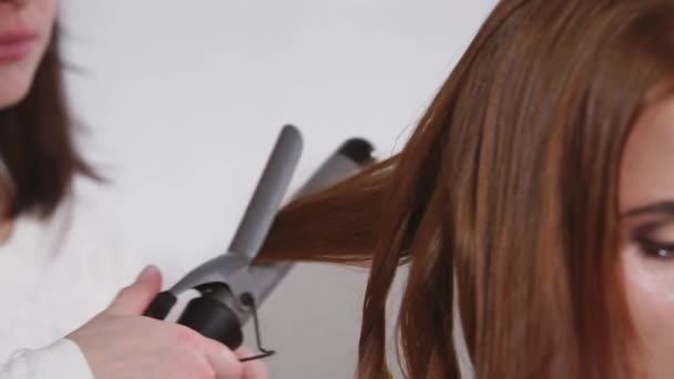 Zbliżenie: Lokówka do dłoni fryzjerskiego, Dokonywanie fryzurę dla kobiety - Materiał filmowy, wideo