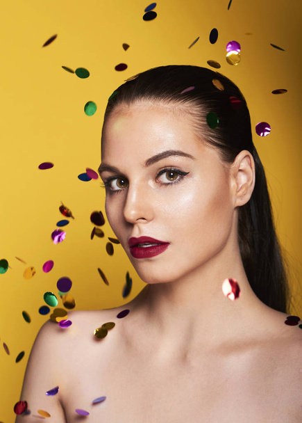 Closeup of Beauty Woman Face with confetti. Portrait Of Beautiful Young Female Model With Soft Smooth Skin And Professional Facial Makeup - Photo, Image