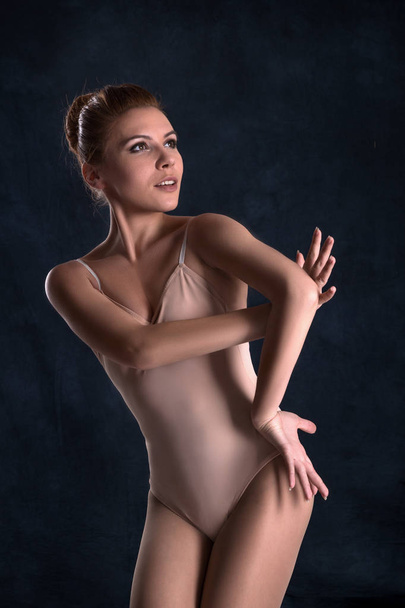 the ballerina  dances on a dark background - Фото, изображение