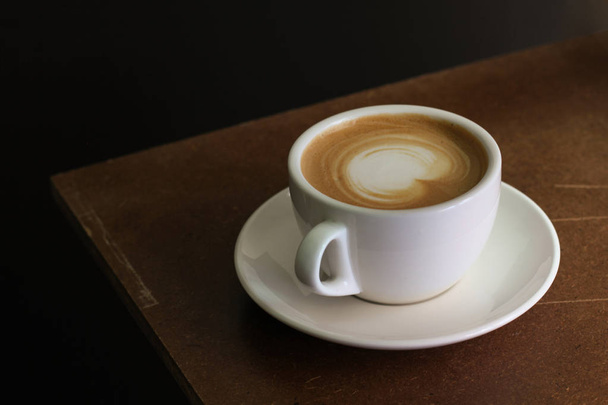 Warme koffie café latte op houten tafel - Foto, afbeelding