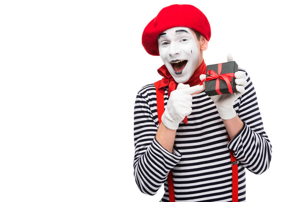 laughing mime pointing on present box isolated on white - Photo, Image
