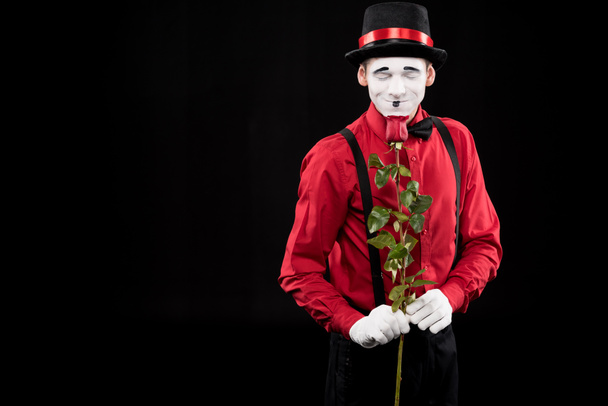 mime sniffing red rose with closed eyes isolated on black - Photo, Image