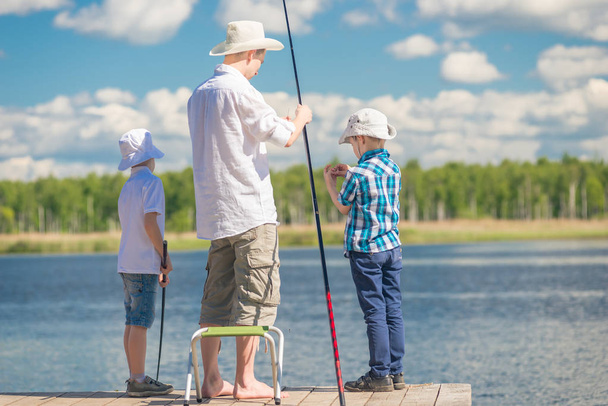a man's hobby - a father with his sons on fishing in good weathe - Fotoğraf, Görsel
