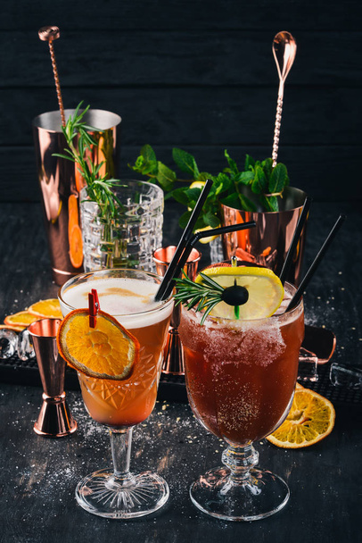 Two alcoholic cocktail Mai Tai, Bloody Mary. On a black wooden background. - 写真・画像