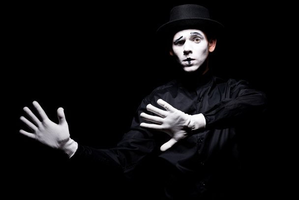 mime pretending touching something isolated on black - Φωτογραφία, εικόνα