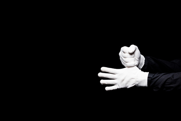 cropped image of mime hiding thumb isolated on black - Фото, изображение