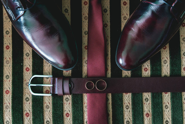cinturón, corbata y zapatos en un sofá vintage
 - Foto, Imagen