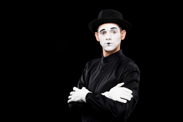 mime standing with crossed arms and looking at camera isolated on black - Photo, Image