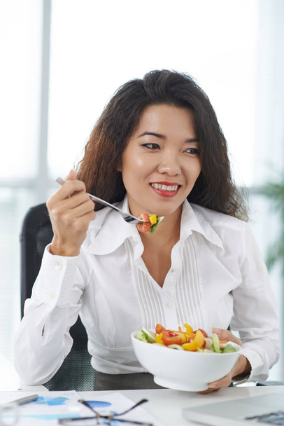Iloinen aasialainen liiketoiminnan nainen ottaa salaattia työhön
 - Valokuva, kuva