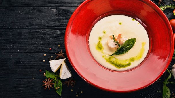 Cheese Soup with Shrimp. Brie cheese Top view. On a black wooden background. Copy space. - Fotó, kép