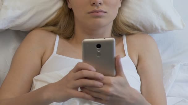 Student female with smartphone in bed, chatting in social networks until morning - Materiaali, video