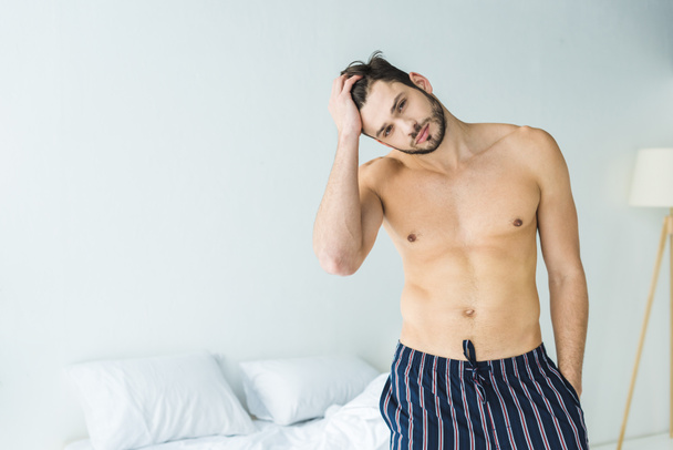 handsome shirtless man posing in bedroom in the morning - Fotoğraf, Görsel