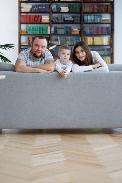 Образ щасливої жінки і чоловіка з хлопчиками на сірому дивані
 - Фото, зображення