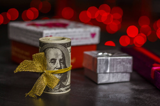 Una pila de dólares cerca de cajas de regalo
 - Foto, imagen