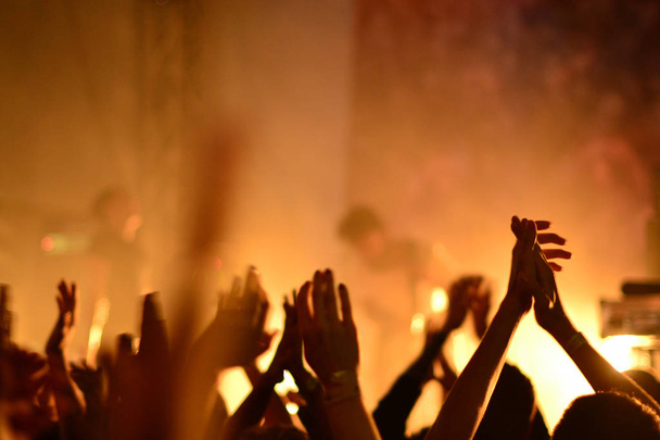 силуэты концертной толпы перед яркими огнями сцены - Фото, изображение