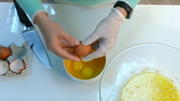 Las manos rompen los huevos en un tazón
 - Metraje, vídeo