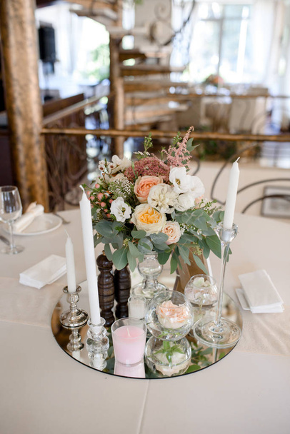 花やミラー プレートのキャンドルでテーブルを装飾 - 写真・画像