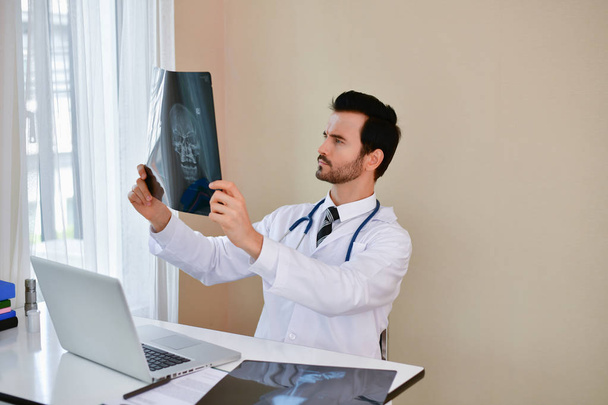Smiling doctor posing in the office, he is wearing a stethoscope - Fotografie, Obrázek