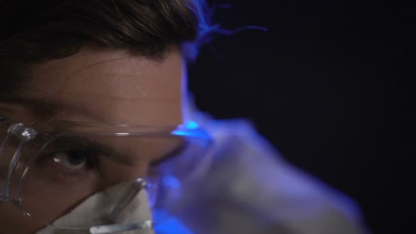 Man wearing lab costume in clandestine laboratory, illegal drug producing - Materiaali, video