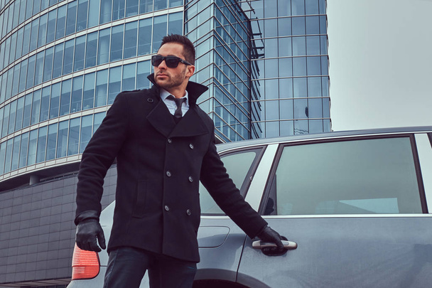 Portrét pohledný závažné mužské bodyguard v sluneční brýle otevření dveří auta, aby podnikatel. - Fotografie, Obrázek