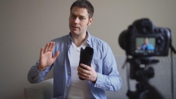 Yakışıklı adam fotoğraf makinesi lensleri hakkında video blogu yapıyor.. - Video, Çekim