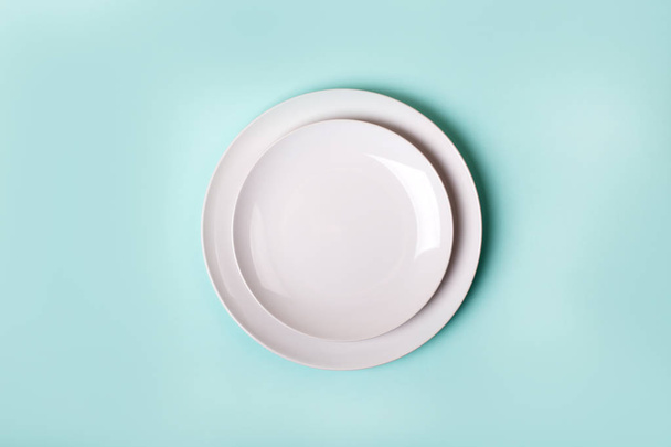 ceramics plate isolated on turquoise background - top view - Foto, afbeelding
