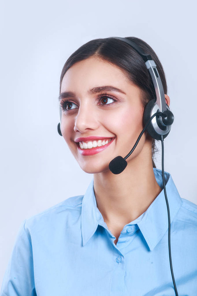 Женщина работница обслуживания клиентов, улыбающийся оператор колл-центра с телефонной гарнитурой
 - Фото, изображение