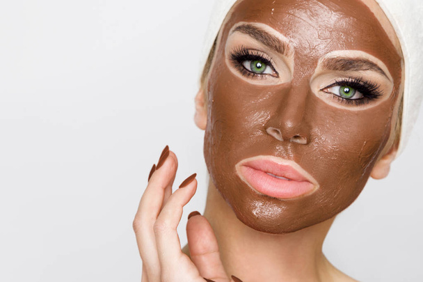 Beautiful blonde woman with a facial mask, beauty spa.Chocolate face mask - Photo, Image
