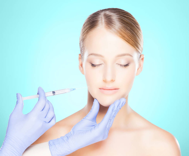 Doctor injecting in a beautiful face of a young woman. Plastic surgery concept. - Valokuva, kuva