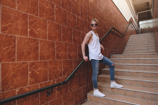 Young hipster man posing standing on the stairs - Fotó, kép