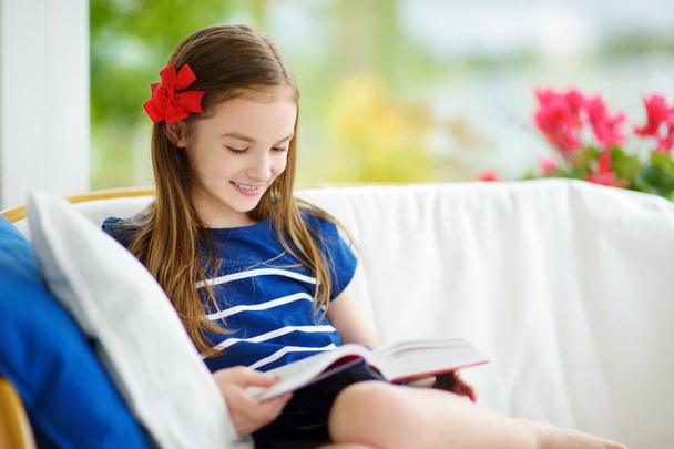 girl reading book in living room - Foto, Imagen