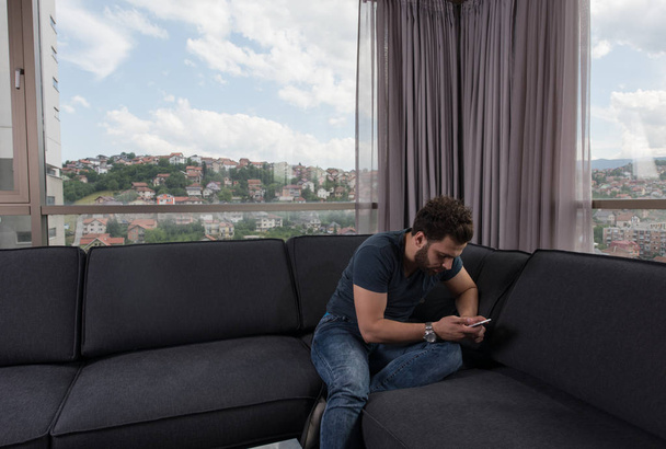 young casual man using a mobile phone at home - Photo, image
