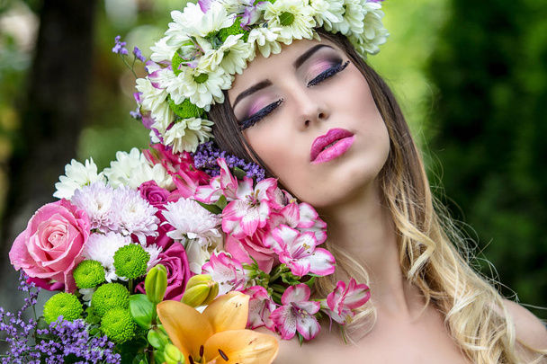 Beautiful woman in a flower wreath a in summer at sunset. - Photo, Image