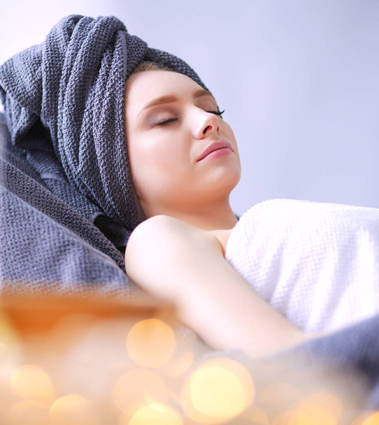 Young woman lying on a massage table,relaxing with eyes closed - Фото, зображення