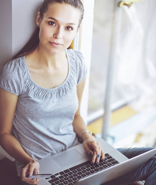 Young beautiful woman using a laptop computer at home - Fotoğraf, Görsel