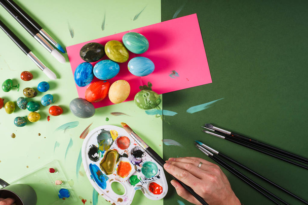 Colored chicken and quail easter eggs, brushes, palette and pain - 写真・画像