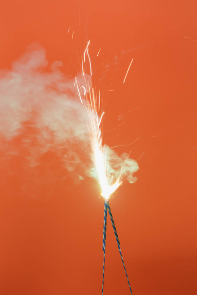 A narancsszínű háttér-két égő tűzijáték - Fotó, kép