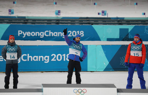 PYEONGCHANG, SOUTH KOREA - FEBRUARY 18, 2018: Simon Schempp GER (L), Martin Fourcade FRA and Emil Hegle Svendsen NOR at the biathlon men`s 15km mass start venue celebration at the 2018 Winter Olympics - Valokuva, kuva