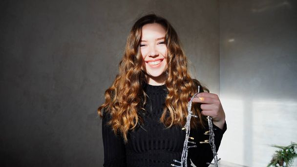 junge Frau lächelt in die Kamera mit lockigem Haar - Foto, Bild
