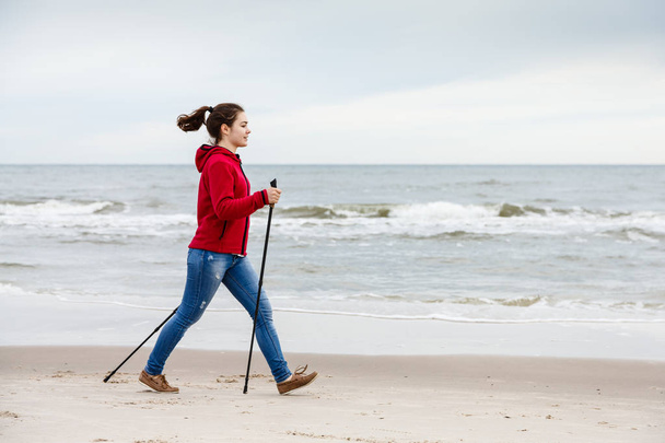 Nordic walking - young woman working out on beach - Фото, зображення