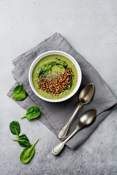 Useful smoothies from spinach with buckwheat flakes in ceramic bowls on gray concrete table background. Selective focus. Top view. Copy space. - Fotoğraf, Görsel