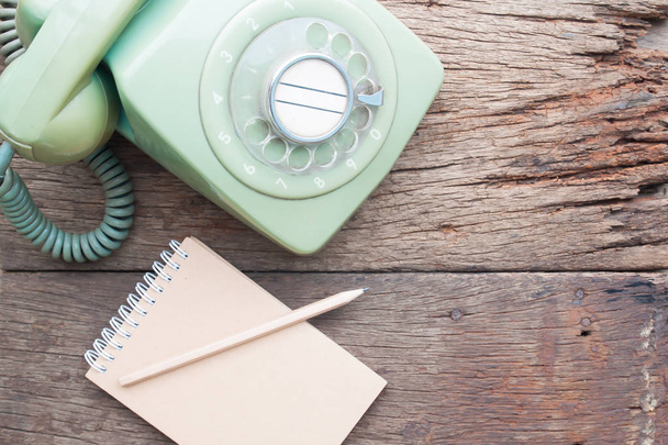 Teléfono de casa de estilo vintage con diario de cuaderno en mesa de madera grunge
 - Foto, imagen