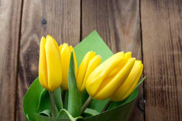 Gelbe Tulpen auf einem hölzernen Hintergrund - Foto, Bild