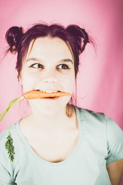 young teenage girl with carrot in her mouth - Fotografie, Obrázek