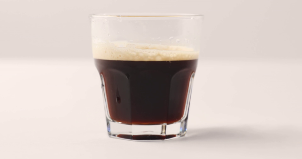 Verter la leche en vidrio Old Fashioned con café negro sobre fondo blanco
 - Metraje, vídeo