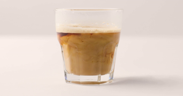 Glass with black coffee on white background with reverse footage - Footage, Video