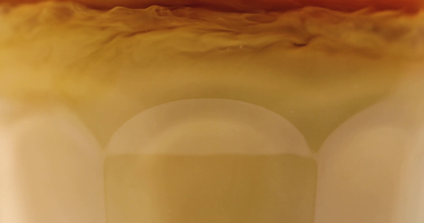 Vista close-up de leite derramando em vidro com café preto
 - Filmagem, Vídeo