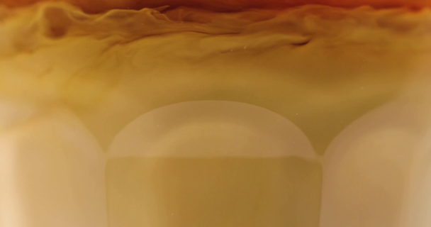 Vista de perto de redemoinhos de leite em vidro com café
 - Filmagem, Vídeo