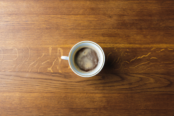 Tahta masadaki kahve fincanının üst görüntüsü. - Fotoğraf, Görsel