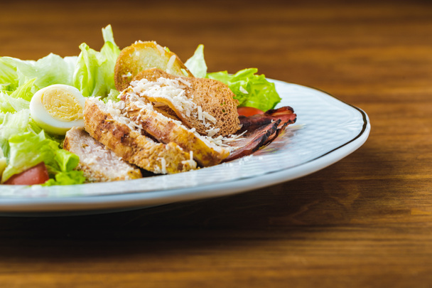 close-up view of delicious caesar salad on wooden table - Photo, Image